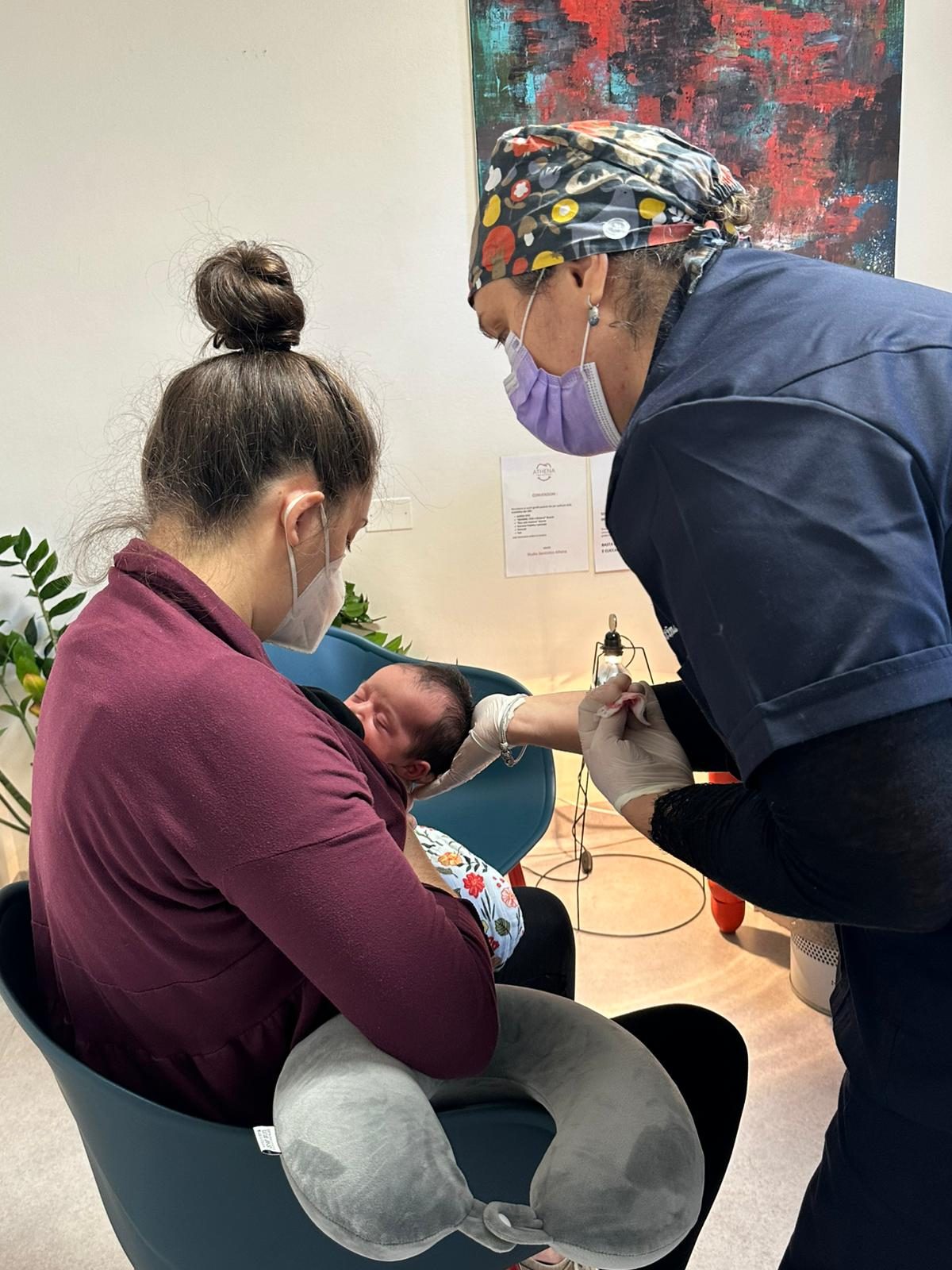Valutazione del frenulo di un neonato in studio, con la mamma